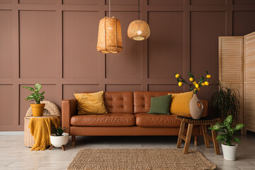 Interior of stylish living room with cozy brown sofa, houseplants and wicker lamps