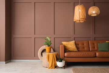 Interior of stylish living room with cozy brown sofa, houseplants and wicker lamps