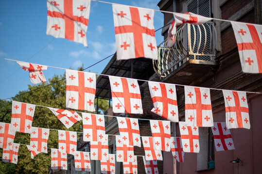 Multiple Georgian flags hanging in a row, creating a festive atmosphere in Old Town in Tbilisi, Georgia