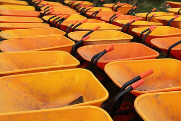 A Collection of Orange Plastic Gardening Wheelbarrows.