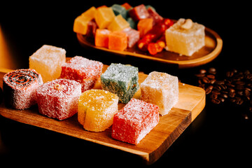 Turkish delights displayed on a wooden platter with colorful treats in the background