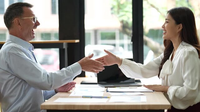 Professional business partners sealing collaborative agreement with confident handshake after successful contract signing, expressing mutual satisfaction and professional respect