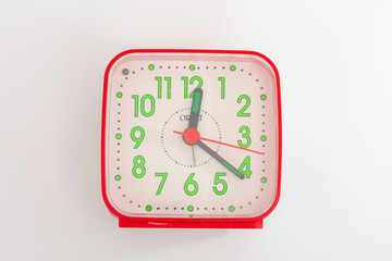 
A classic red analog alarm clock isolated on a clean white background, a symbolic image for time,...