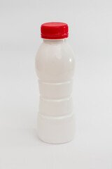 
A generic white plastic bottle with a bold red cap, isolated against a dark background, perfect...