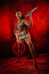 Viking woman warrior posing with long two handed sword on old wooden wall background in the red...