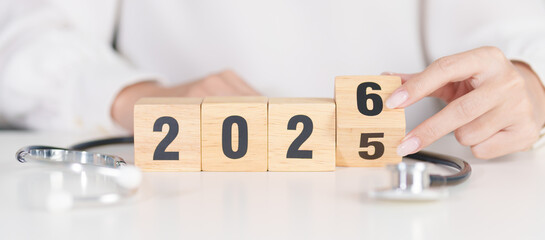 2025 end year to Happy New Year 2026 with Stethoscope of doctor and heart shape on table. health...