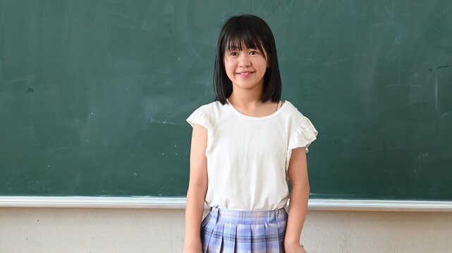 クイズに答える女子学生　学校の教室で○✕を出す教育イメージ
