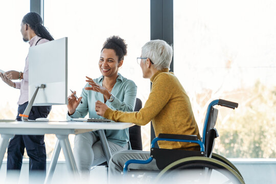 A diverse group of young professionals, including senior businesswomen entrepreneur in a wheelchair