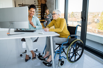 A diverse group of young professionals, including senior businesswomen entrepreneur in a wheelchair