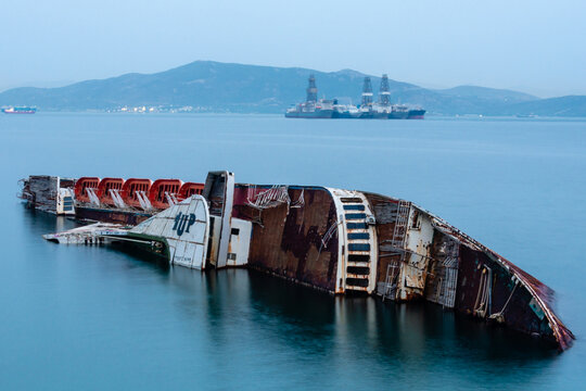 Shipwreck in Elefsina bay with offshore platforms, Attica, Greece.