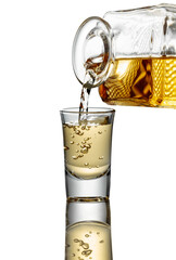 Gold liquor pouring into a glass on a white background.