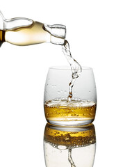 Pouring whiskey from a bottle into a glass on a white background.