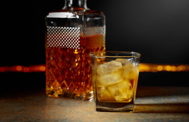 Whiskey with ice on a dark background.