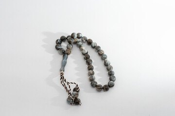 
A set of marbled gray and white prayer beads, isolated on a clean white background, symbolizing...