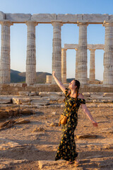Tourist posing at Temple of Poseidon in Sounion, Attica, Greece.