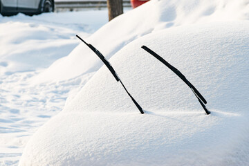 windshield wipers raised up on a snow-covered car