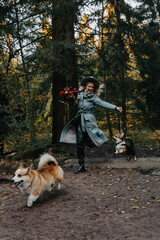A young Caucasian woman with brown hair wearing a coat holds a bouquet of flowers while playing...
