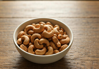 Fototapeta premium Cashews in bowl on rustic wood table 