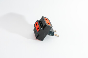 A black electrical adapter with orange sockets, isolated on a clean white background, symbolizing...
