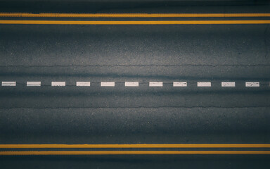 Aerial view of highway asphalt road with yellow and white lane markings seamless texture