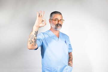 Doctor in scrubs making OK gesture.