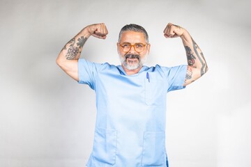 Tattooed man in medical scrubs flexing muscles.