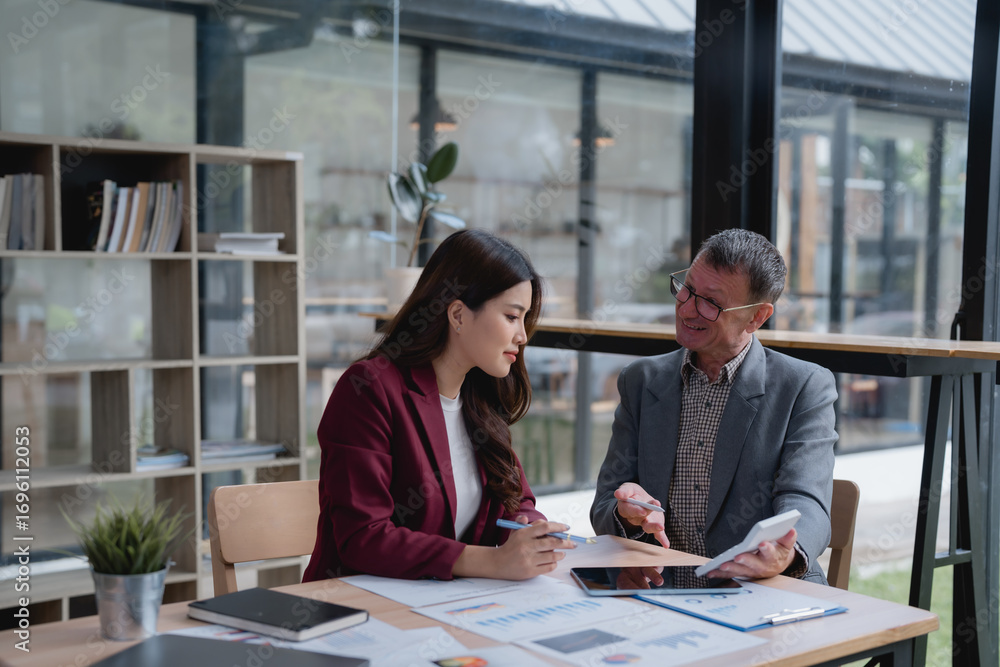 Poster Senior businessman showing calculator to young businesswoman working together in office meeting analyzing financial statistics data charts graphs reporting document discussing project stats progress u