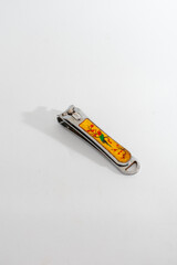 A decorated metal nail clipper, isolated on a clean white background, symbolizing personal...