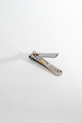 
A metal nail clipper, opened and ready for use, isolated on a clean white background, symbolizing...