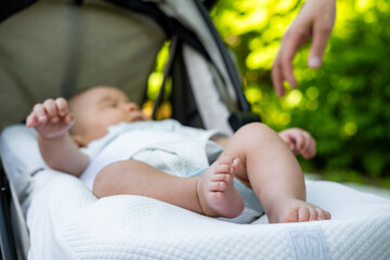 Newborn baby feet in the baby carriage, infant foot first week of life