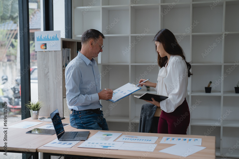 Poster two business colleagues analyzing financial charts and graphs while discussing growth strategies dur