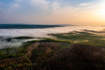 Misty landscape at sunrise with rolling hills