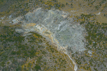Aerial view of a geothermal landscape with steam and rocks