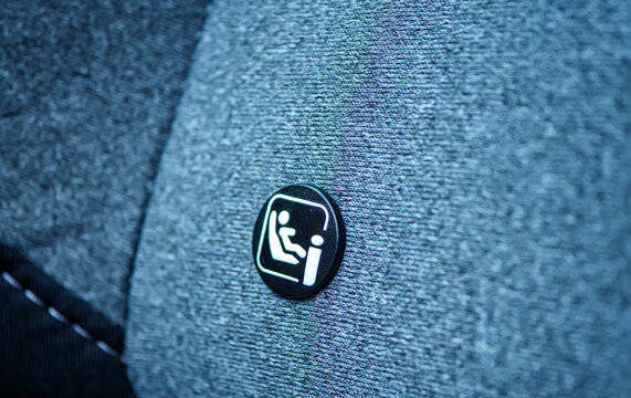The Isofix international standard symbol for child safety seat anchor points in a car The icon on the gray fabric seat indicates a secure and easy way to install a child's car seat