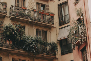Charming European Balconies. A quaint view of the old buildings with cozy balconies overflowing with lush greenery plants and flowers, evoking a sense of peaceful urban life. Vintage aesthetic touch.