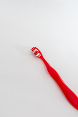 A single red and white toothbrush, isolated on a clean white background, symbolizing oral hygiene...