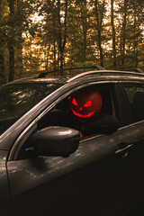 Autumn SUV with Driver with Pumpkin Head in Forest