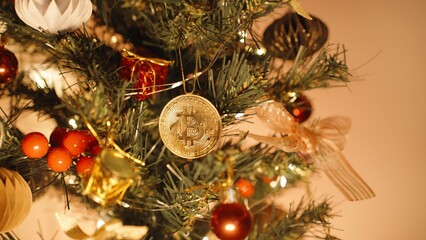 Bitcoin Ornament Hanging on Christmas Tree Surrounded by Traditional Holiday Decor and Warm Lights, Close Up, Festive Cryptocurrency Concept