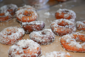 Fresh home made donuts, doughnuts sprinkled with sugary toppings on a table