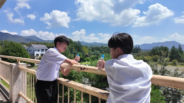 校庭を眺める男子中学生と友達　学校生活