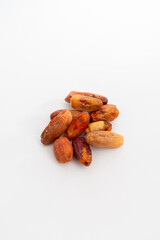 A small pile of dried dates or fruit, isolated on a clean white background, symbolizing healthy...