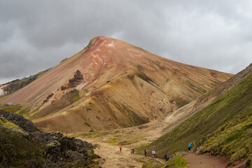 Hikers walking in colorful volcanic landscape of landmannalaugar, iceland