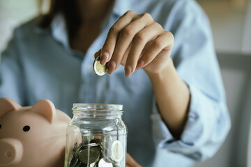 An adult holds a coin, which symbolizes finance, investing, saving, retirement planning, profits,...