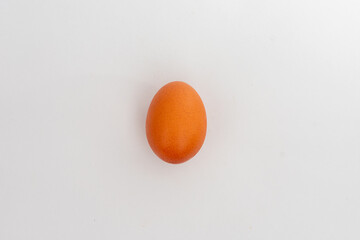 A single brown egg, centered and isolated on a clean white background, symbolizing food, nutrition,...