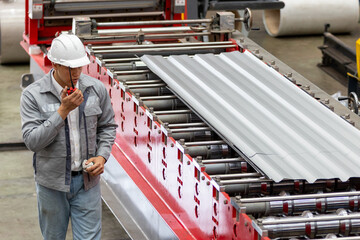 Industrial Engineer in Hard Hats.Work at the Heavy Industry Metal Sheet Manufacturing Factory....