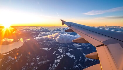 Aerial view of a sunset over snow-capped mountains from an airplane window