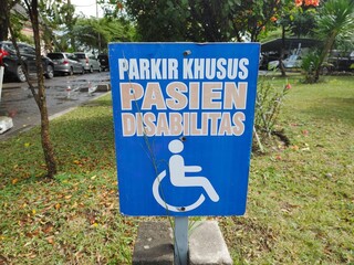Reserved parking sign for handicapped. Disabled parking space with white blue painted sign of...