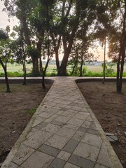 View of an empty city park at dusk or early evening with brick walkways
