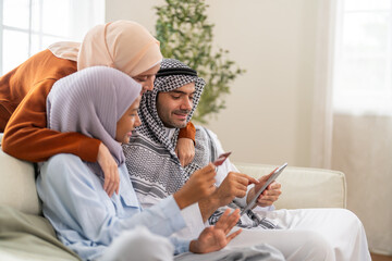 Muslim family learning online use tablet for homeschool education, daughter engaged in e-learning while parents guide with modern knowledge digital, online entertainment and muslim kids development