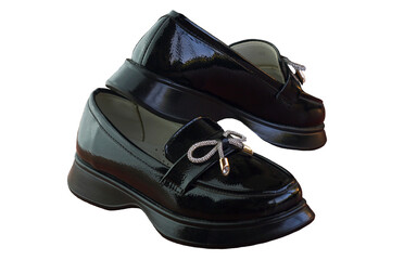 Shiny black girls' shoes stand on a white background